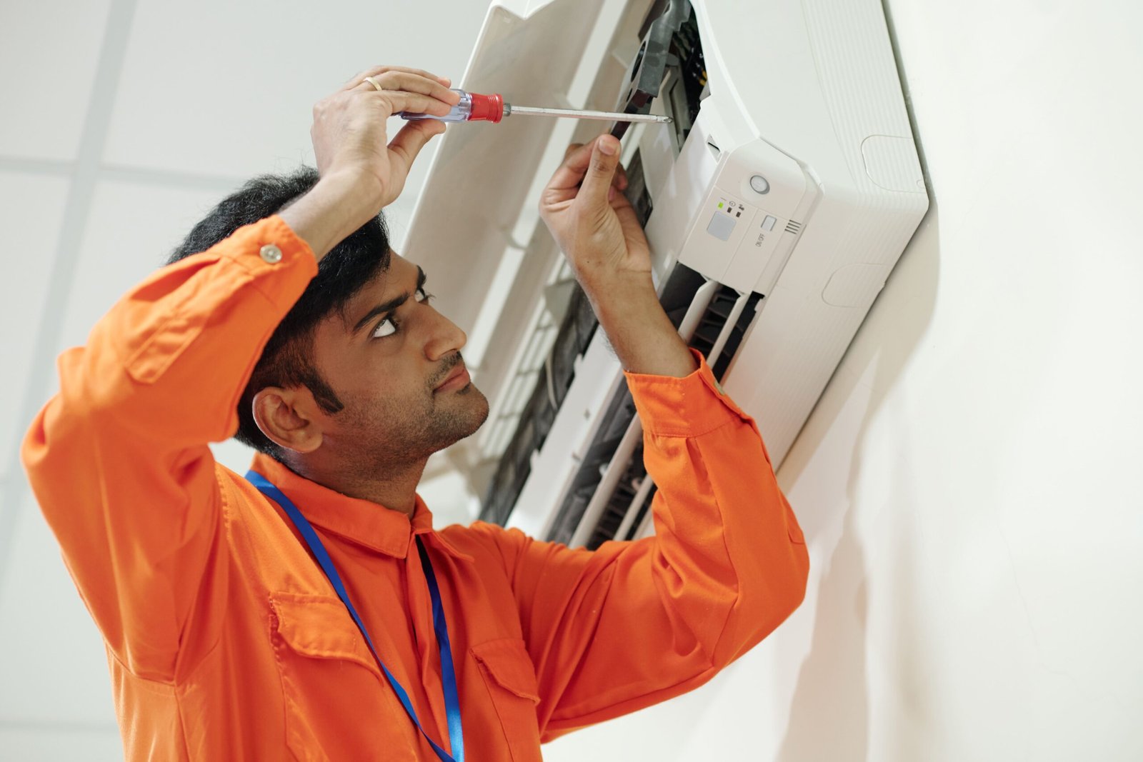 indian-man-setting-up-air-conditioner-2023-11-27-04-52-36-utc-min